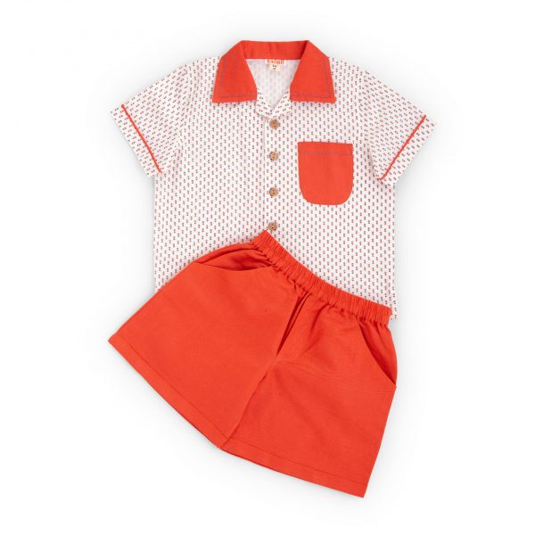 Flatlay of orange shorts and printed white cotton shirt set