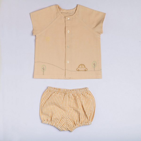 Flatlay of hand-embroidered peach jabla with raglan sleeve and matching gingham bloomers set