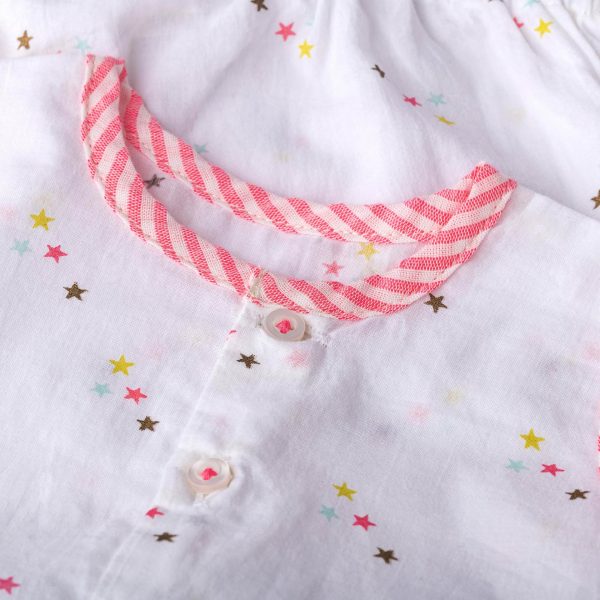 Close up of star print baby onesie with buttons down the front and neon striped piping along edges and collar
