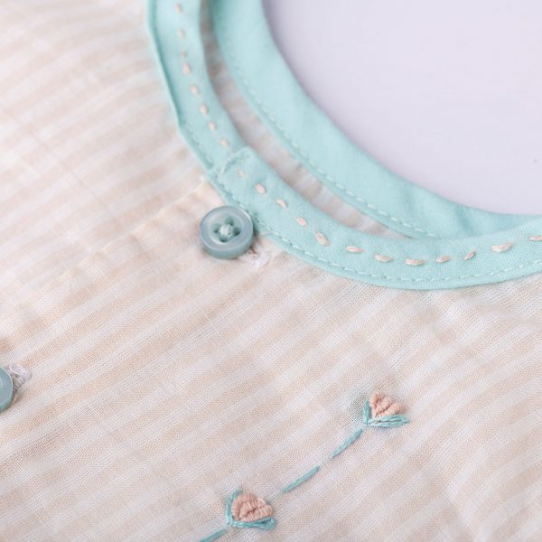 Hand embroidery on a peach stripe infant neckline detail