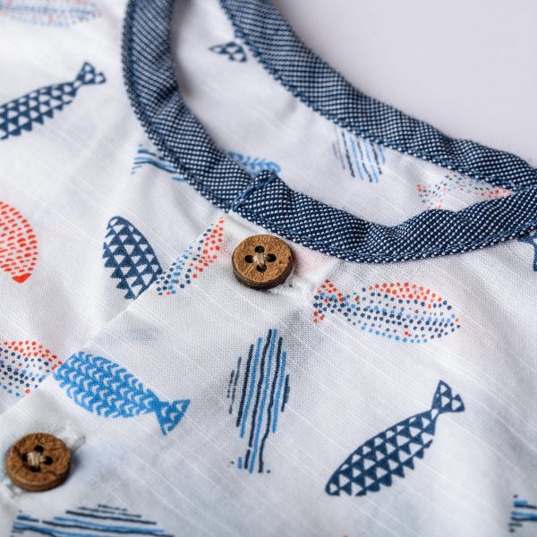Infant onesie close up showing fish print detail and button placket