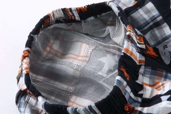 Close-up of mesh lining in patchwork swim shorts with an elasticated waist