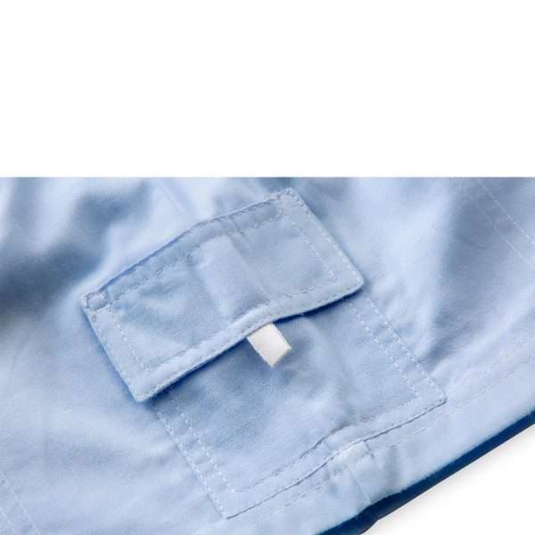 Close up of powder blue shorts with side pockets with flaps and white stitching