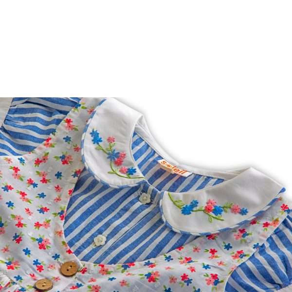 Close-up of hand embroidered collar in blue striped cotton dress with floral overdress