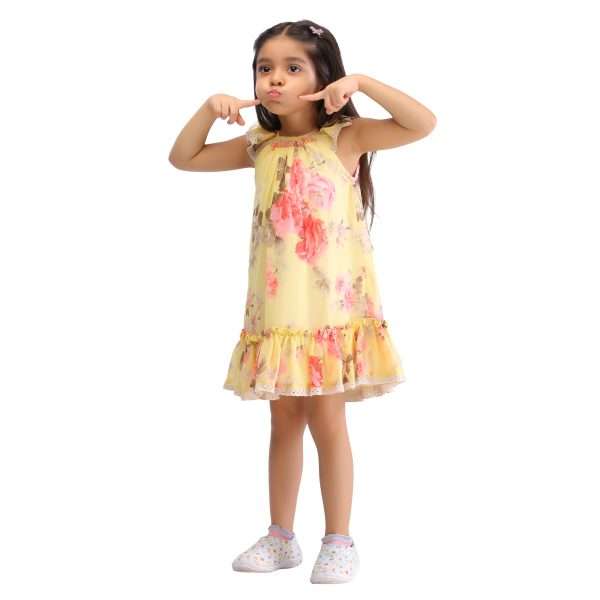 A little girl in yellow floral printed chiffon dress with hand smocked neckline
