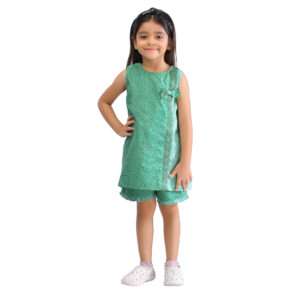 Smiling girl wearing a sleeveless a-line tunic and matched shorts in green print and gingham