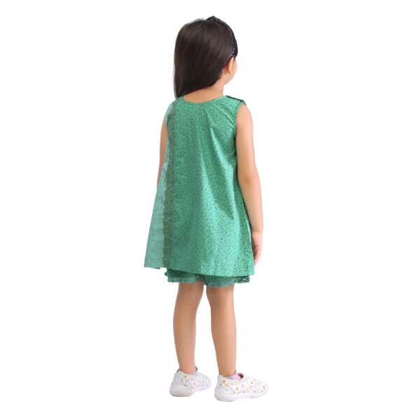 Back view of a girl wearing a green print tunic and shorts