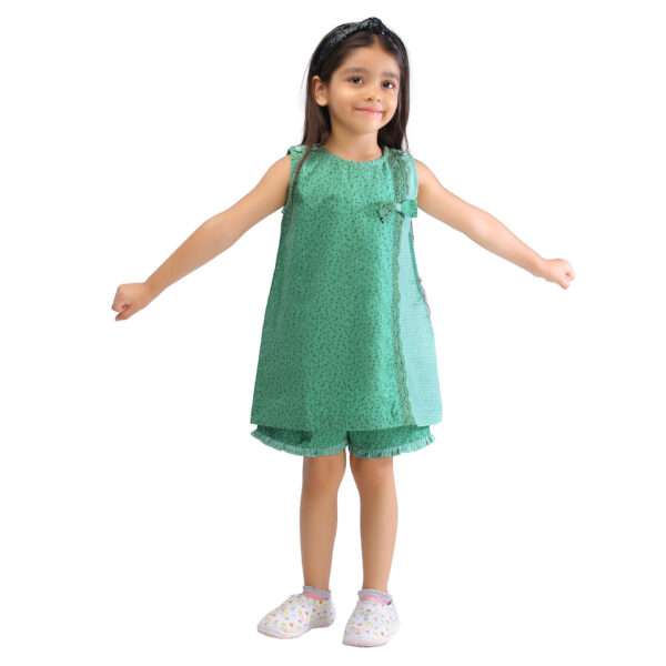 Girl weaing a long a-line tunic with matched shorts in a green print