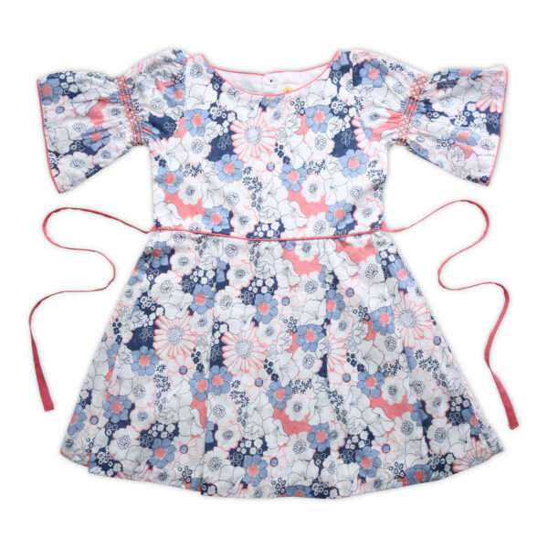 Flatlay of swiss dot pink and blue floral printed cotton dress with bell sleeves