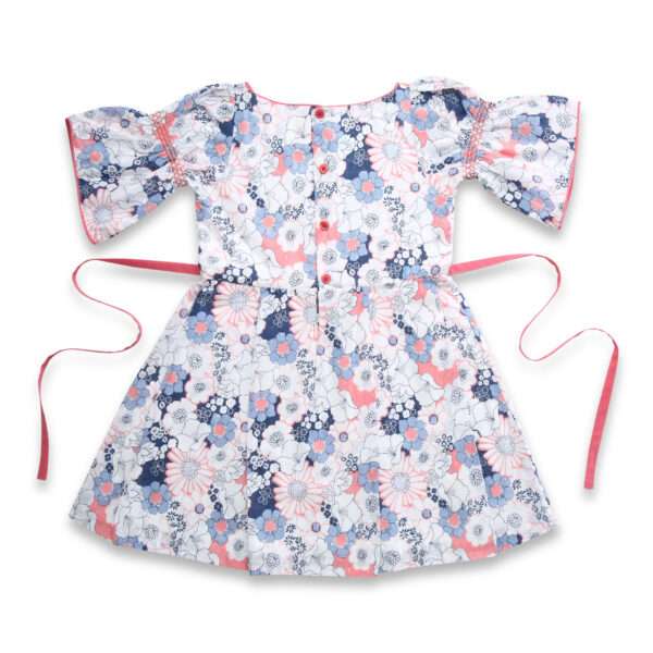 Flatlay of swiss dot pink and blue floral printed cotton dress with bell sleeves