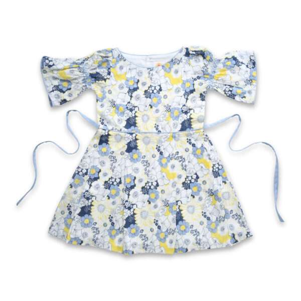 Flatlay of swiss dot blue floral printed cotton dress with boat neck and elasticated shirring on bell sleeves