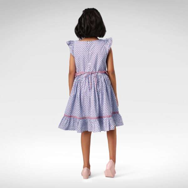 Back view of girl wearing a ruffle hem , flutter sleeve printed dress with a back waist tie