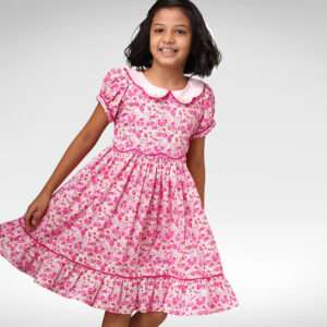 A young girl twirls in a ruffle hem pink dress with a pretty pink collar with hand embroidery