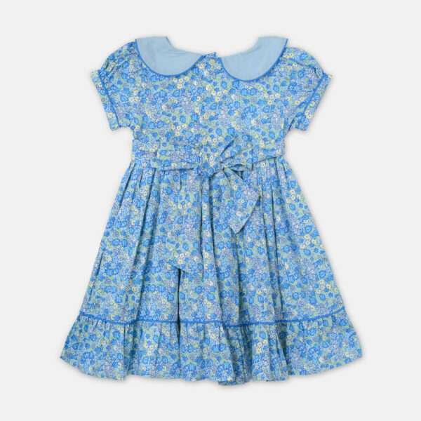 Rear image of blue floral dress with scalloped waistline, puff sleeves, ruffled hem, and back ties