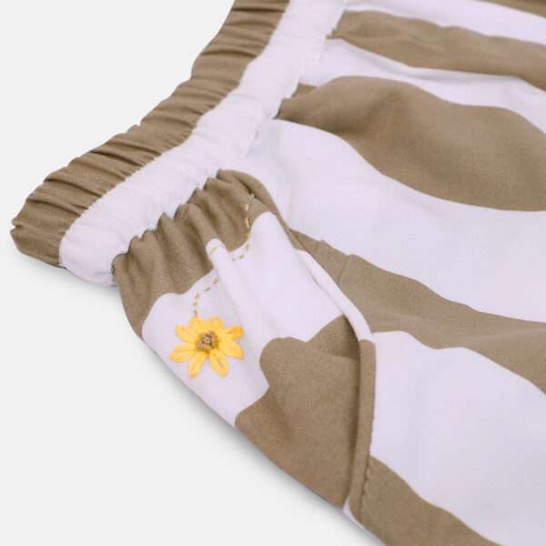 Little girl in striped cotton shorts with scalloped edges and hand embroidered pocket details