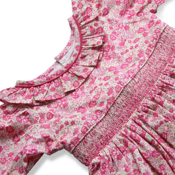 Close-up of pink floral embroidered cotton dress with a hand smocked waistline and ruffled collar