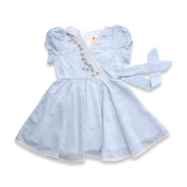 Flatlay of blue striped cotton dress with delicate crochet-style lace trim, floral hand-embroidery and faux cross-over