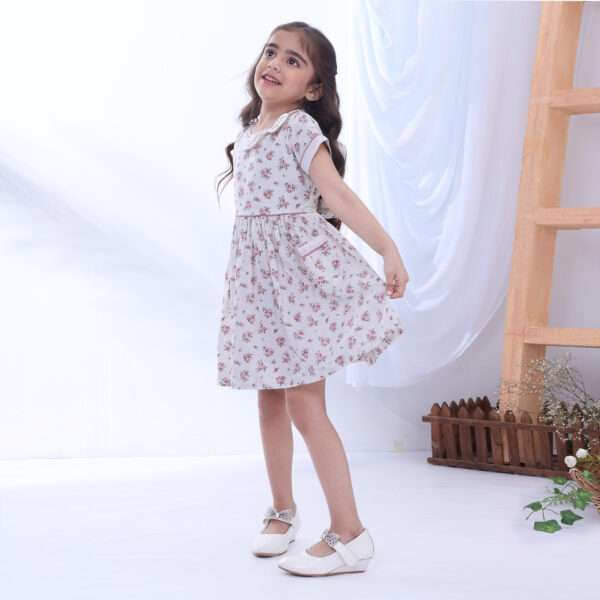 Girl posing wearing ivory floral printed cotton dress with hand embroidered details