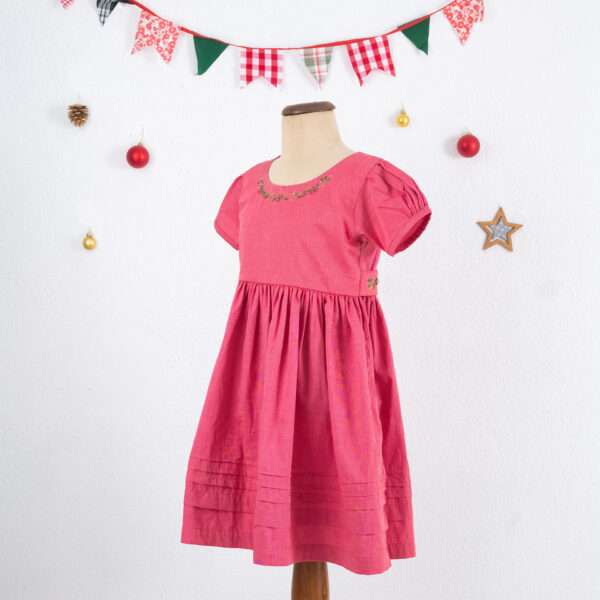 Mannequin image of red chambray dress with hand embroidered neckline, puff sleeves, and pleated hem