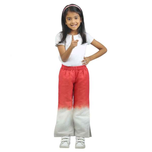 A little girl in red and white tie-dye bootleg pants with side slits and elasticated waistband