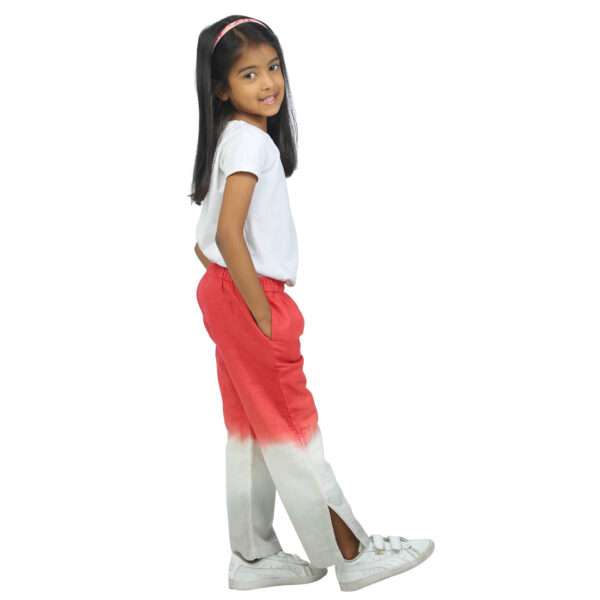 Side view of a girl wearing coral and grey linen pants with side slits