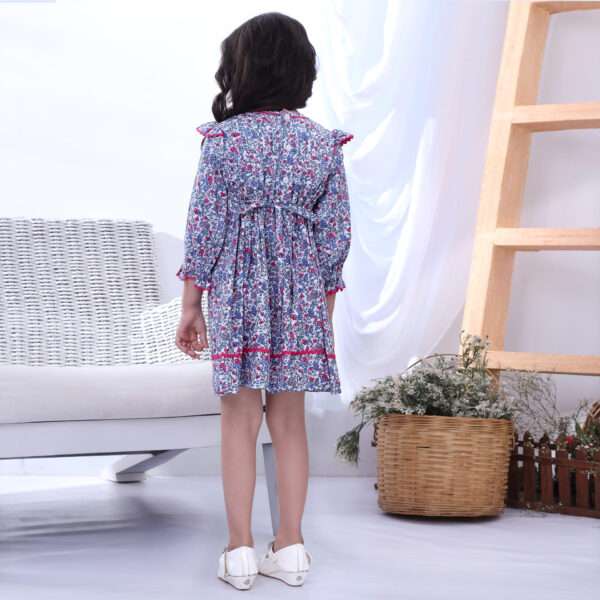 Rear image of a little girl in floral full sleeve dress with pin tucks, pink ric rac, and hand embroidery