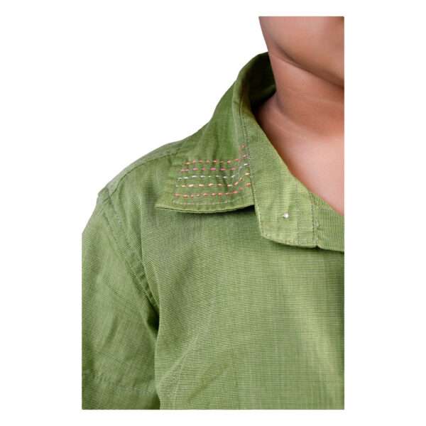 Close up of a little boy in green shirt with wood buttons and kantha hand embroidery on collar