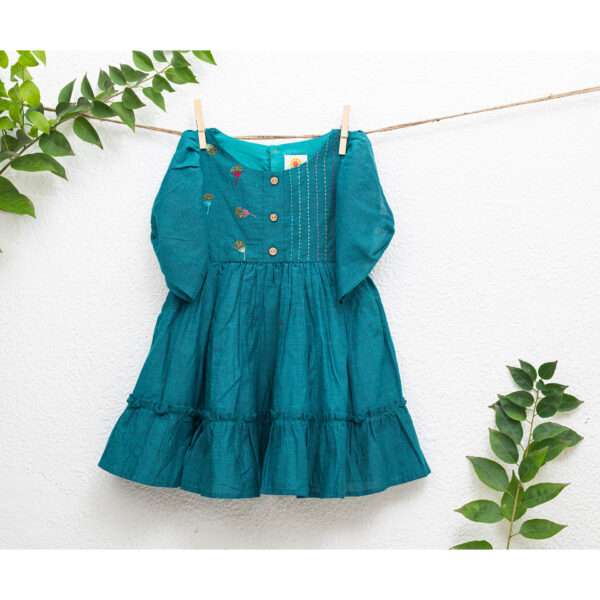 Teal girls festive dress on a clothesline with hand embroidery and beadwork