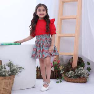 Girl wearing and indian ethnic print shirred elastic skirt and red swiss dot ruffle blouse