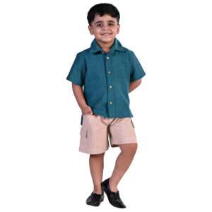 A little boy wearing peacock blue shirt with Kantha hand embroidered collar and khaki shorts