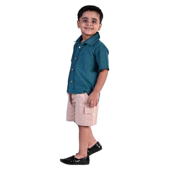 Side view of a little boy wearing peacock blue shirt with Kantha hand embroidered collar and khaki shorts
