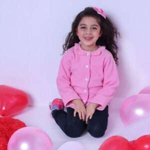 A little girl wearing fleece jacket lined in soft pink cotton, with pink gingham edging and a neckline ruffle