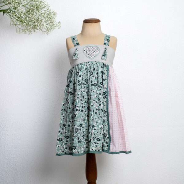 Mannequin shot of a sleeveless strappy shoulder dress with a heart patchwork applique on the yoke