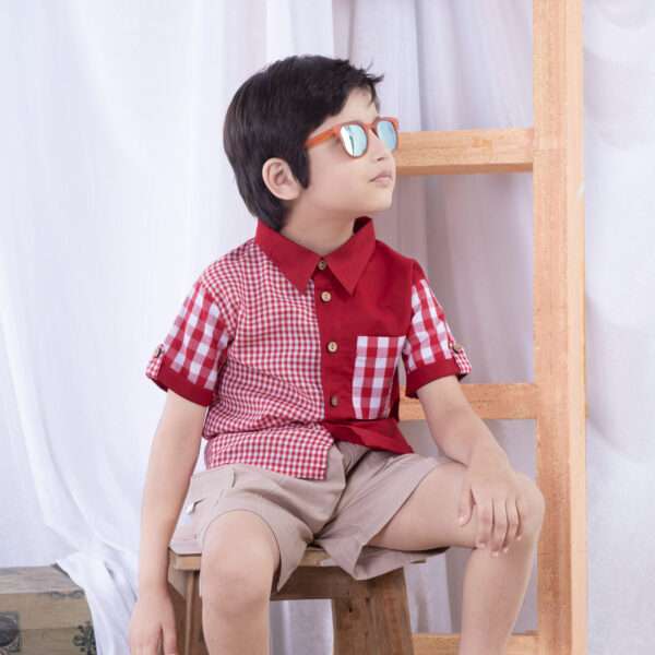 A little boy in red checked patchwork shirt with big and micro gingham and solid red voile with double pockets