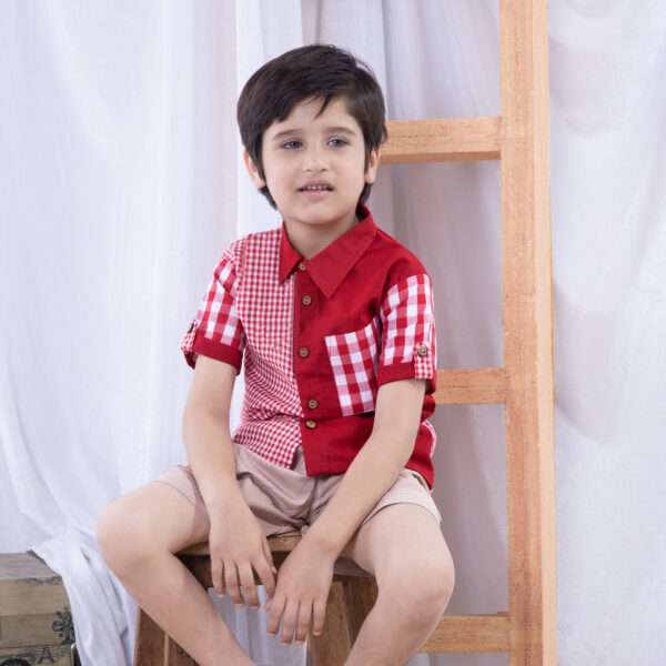 A boy dressed in a smart big and micro red gingham and solid red voile patchwork shirt