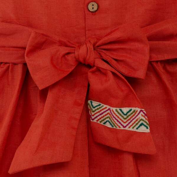 Close-up of the back bow of burnt-orange linen dress with colourful Kantha-work hand-embroidered details
