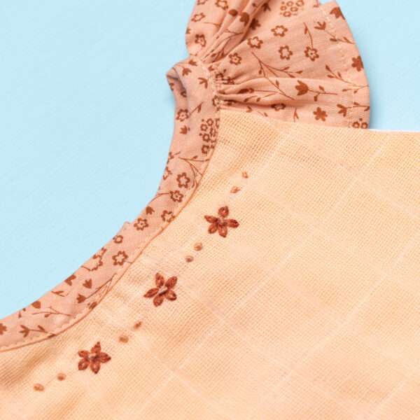 Close-up of neckline ruffles and hand embroidery in peach gauze tunic with matching floral shorts set