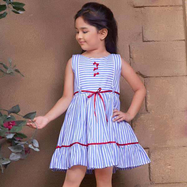 Girl poses in a blue stripe dress with red satin trims