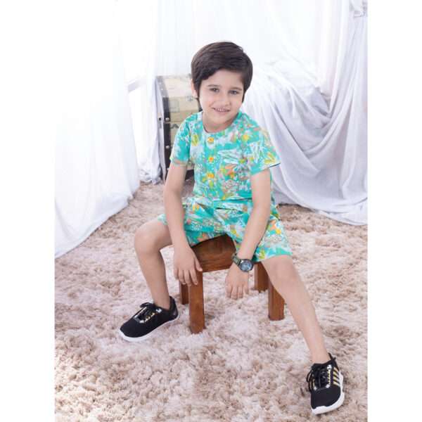 Little boy in turquoise palm tree print shirt and shorts set
