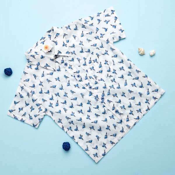Flatlay of white bird print shirt with buttons down the front