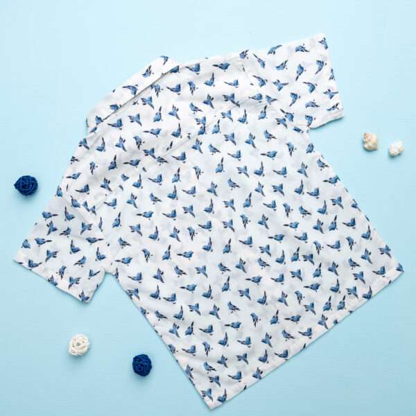 Back of a boys shirt with half sleeves in an ivory and blue bird print