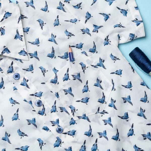 Close-up of the pocket in soft cotton bird printed collared shirt with contrast blue buttons