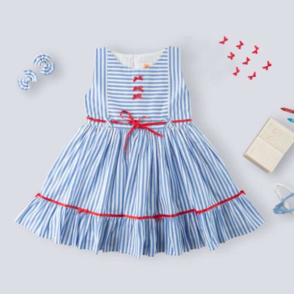 Flatlay of blue stripe cotton dress with satin bows on the hem ruffle and bodice, a satin belt at the waist