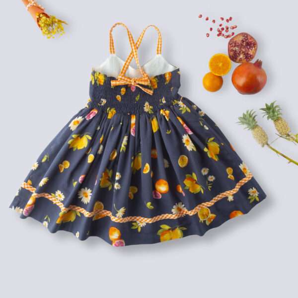 Flatlay of rear side of strappy shoulder floral and fruit printed navy dress with contrast trims