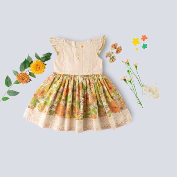 Flatlay of floral cotton dress with a peach yoke and hem with beautiful lace trims and hand embroidery