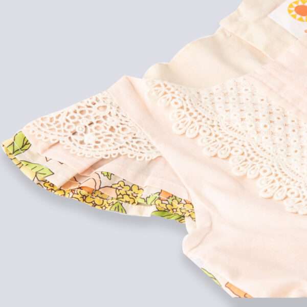 Close-up of peach yoke and sleeve of floral cotton dress with beautiful lace trims and hand embroidery