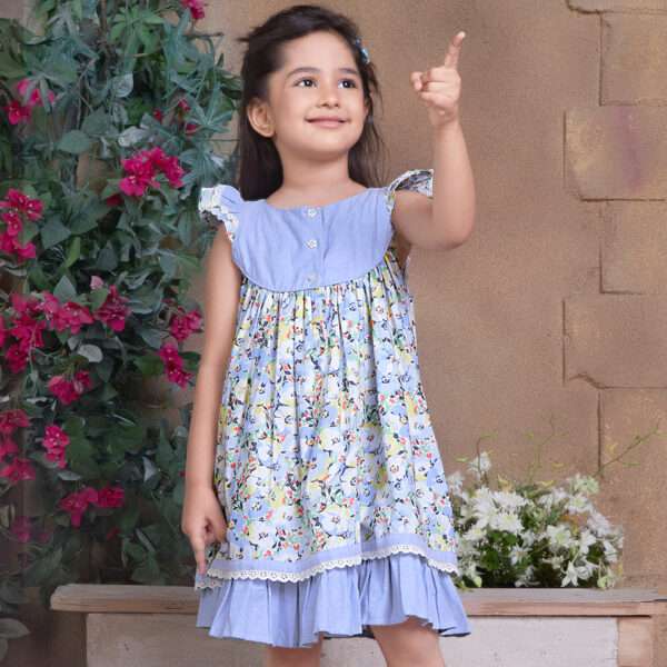 A little girl in blue chambray floral printed cotton dress with flutter sleeves, eyelet lace trims and ruffled hem
