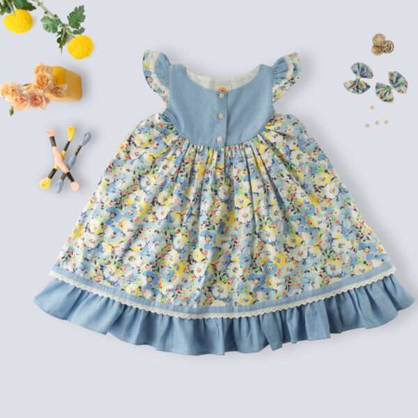 Flatlay of blue chambray floral printed cotton dress with flutter sleeves, eyelet lace trims and ruffled hem