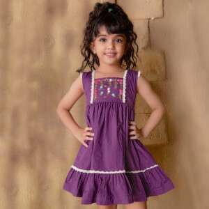 A little girl in magenta dress with hand embroidered floral garlands, embellished with woven lace and wooden buttons
