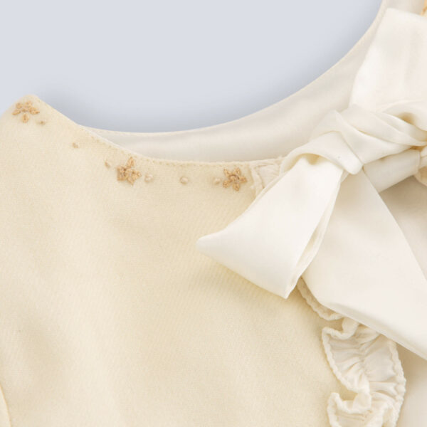 Flat lay view of an ivory bolero embroidered jacket for girls featuring a tie-up sash bow